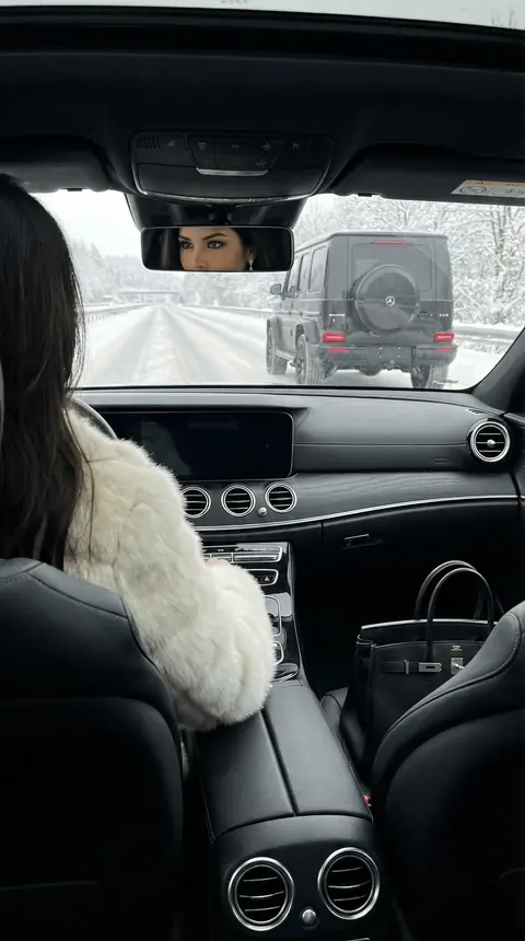 Промт для фотосессии: Девушка за рулем Mercedes на заснеженной трассе с Gelandewagen сзади