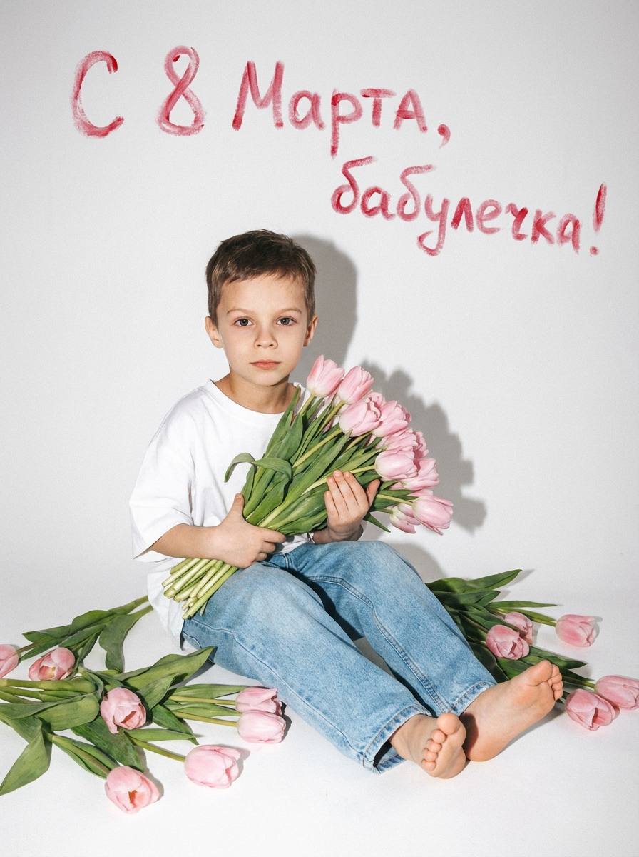 Промт для детской фотосессии к 8 марта: ребенок на белом фоне с розовыми тюльпанами и надписью «С 8 Марта, бабулечка!»